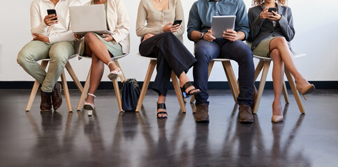 Technology, legs and people waiting for an interview in line at a human resources office as candidates for a vacancy. We are hiring, recruitment and opportunity with man and woman employees online - Powered by Adobe