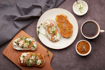 Morning table - sandwiches with zucchini spread and greek yogurt, smoked salmon, coffee cup. Low in calories, FODMAP, KETO diet, superfood flat lay.