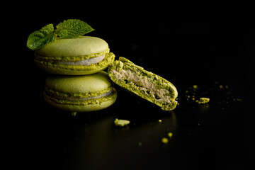 pistachio green macaroons with mint on a dark background