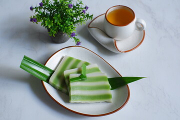 a plate of layer cake or kue lapis and tea 