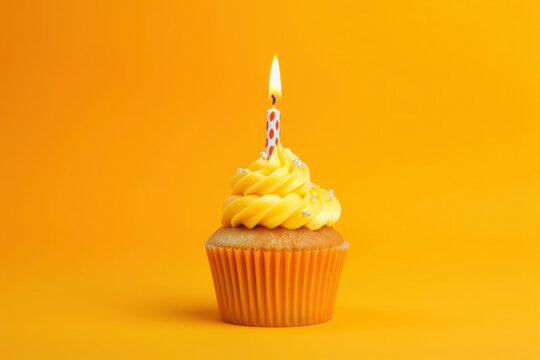A yellow birthday party cupcake with one candle and confetti on yellow background. Generative AI