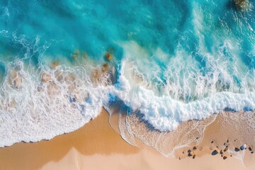 Obraz premium an aerial perspective of a sandy beach meeting the vast blue ocean