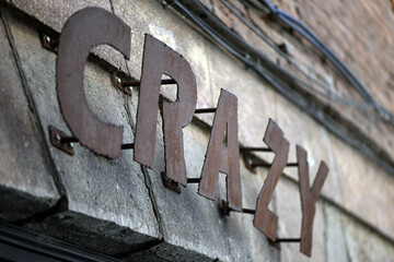 The word "crazy" in metal letters on an old house wall in Spain.