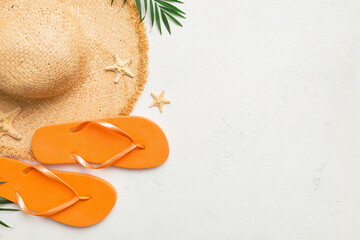 Summer travel concept. Flip flops, summer hat and starfish on white. Top view on colored background