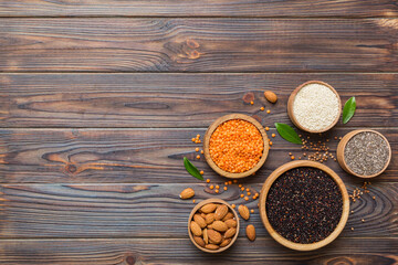 Fototapeta na wymiar Various superfoods in smal bowl on colored background. Superfood as rice, chia, quinoa, lentils, nuts, sesame seeds, almonds. top view copy space
