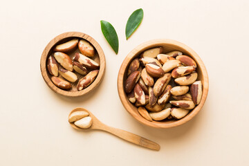 Fresh healthy Brazil nuts in bowl on colored table background. Top view Healthy eating bertholletia concept. Super foods