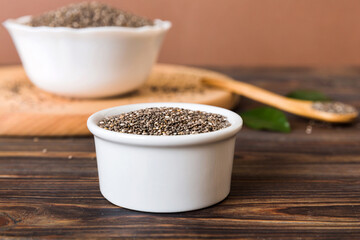 Chia seeds in bowl and spoon on colored background. Healthy Salvia hispanica in small bowl. Healthy superfood