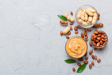 Bowl of peanut butter and peanuts on table background. top view with copy space. Creamy peanut pasta in small bowl