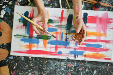 Top view of a creative male artist painting a picture with watercolors on a canvas - Powered by Adobe