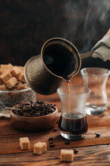 Hand making hot turkish coffee espresso on the dark background