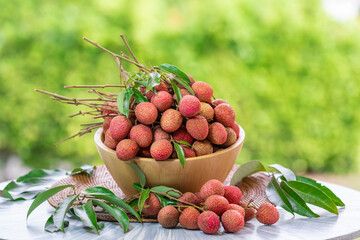 Lychee Fruite in wooden basket, Lychee fruit under sunlight on blurred nature background.
