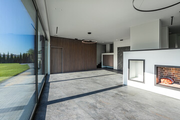 empty hall without furniture of a modern country house with a fireplace