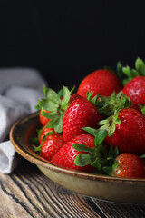 A bowl with ripe bright strawberry in rustic style