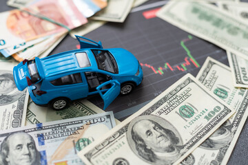 Fototapeta premium Coins stacking on the bank notes in front of the car