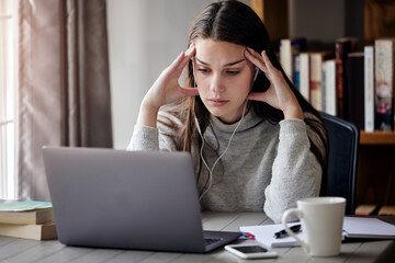 Laptop, headache and education with a student woman feeling burnout while studying alone in her home. Learning, stress and tired with a young female university or college pupil in her house to study