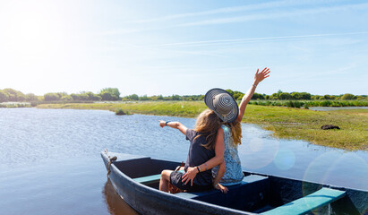Family on wooden row boat in river ( Briere marsh,  Marais de briere, France, Pays de la Loire) © M.studio