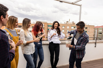 group of friends rooftop party drinking alcohol