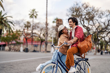 A happy couple with bike is having fun and embracing on the street.