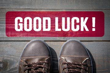 Good Luck. Motivation and inspiration concept. Street shoes on a wooden texture background