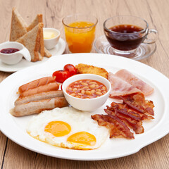 Full English breakfast set with sausage, egg, bacon, baked bean, ham, tomato and toast