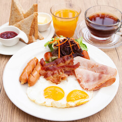 Full English breakfast set with sausage, egg, bacon, baked bean, ham, tomato and toast