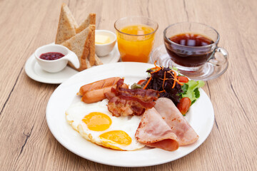 Full English breakfast set with sausage, egg, bacon, baked bean, ham, tomato and toast