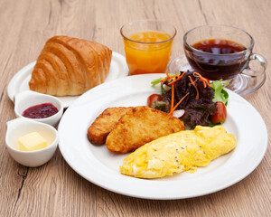 Full breakfast with omelette, hash brown, croissant, orange juice and coffee