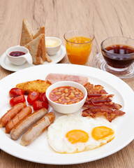 Full English breakfast set with sausage, egg, bacon, baked bean, ham, tomato and toast