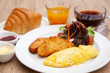 Full breakfast with omelette, hash brown, croissant, orange juice and coffee