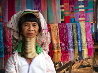 Karen Long Neck woman selling handicrafts in hill tribe village near Chiang Rai, Thailand. - 608167342
