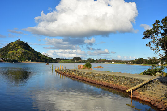 Stone wharf in Pataua River estuary from Pataua North with island in background. Location: Pataua North New Zealand