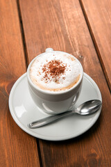 Tazza con cappuccino cremoso con polvere di cacao, colazione italiana 
