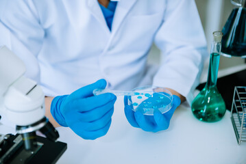 Scientist mixing chemical liquids in the chemistry lab. Researcher working in the chemical laboratory.