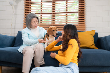 Family vacation, mother, daughter, and beagle puppy relaxing on weekends in the house's leisure room