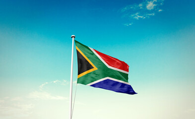 Waving Flag of South Africa in Blue Sky. The symbol of the state on wavy cotton fabric.