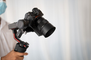 Photographer's hand holding a wedding video camera.