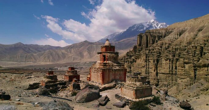 Captivating drone footage orbits a unique structured stupa near Ghami road, Upper Mustang, Nepal. Alluring backdrop of artistic mountains and hills. Discover the beauty of Annapurna Area.