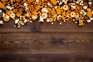 Set of different salty snacks - chips popcorn and nuts. Fast food background