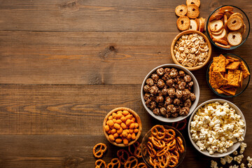 Obraz na płótnie Canvas Many bowls of snacks for party - chips popcorn and nuts