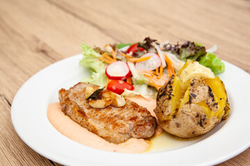 Pork sirloin steak with baked potato and andalouse sauce