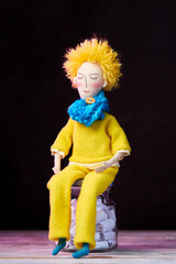Handmade doll boy in the form a little prince at dark background. Vintage funny doll. Sunny doll.