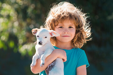 Cute kid hugging puppy dog. Child and puppy playing outside. Dog puppy dream. Dreamy kids hold puppys. Daydreamer child with puppy, outdoor portrait. Dreams pet.