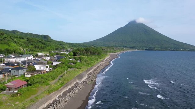 Kagoshima, Japan: Aerial drone footage of the black sand beach along the stunning coast of Kyushu with the Kaimon volcano by the sea in Japan. 