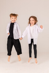 Fototapeta premium Cheerful and happy boy and girl brother and sister having fun on white background. Black and white style
