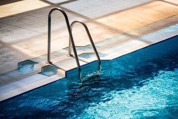 Part of a swimming pool with stairs to enter the water