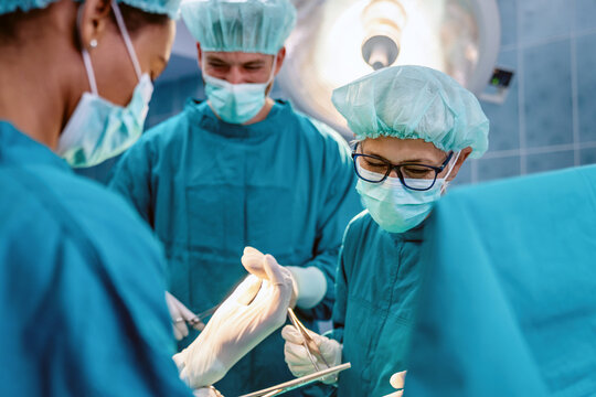 Group of surgeons at operation in operating room at hospital. Surgery, medicine and people concept
