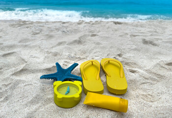 Yellow color with  tropical summer a holiday and accessories on the sand beach background