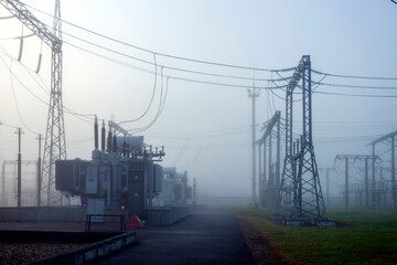 High voltage industrial power plant in the early morning in the fog