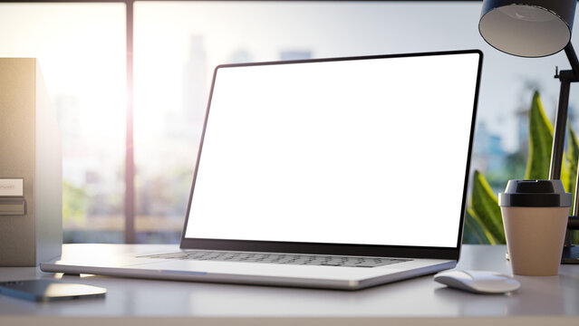 A laptop with a blank frameless screen mockup template is positioned in angled position on a table in an office interior, offering a front view, with office buildings in the background. 3d render