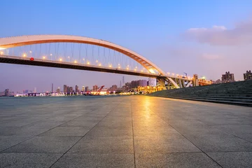 Foto op Canvas Empty square floor and bridge with city skyline at night © ABCDstock